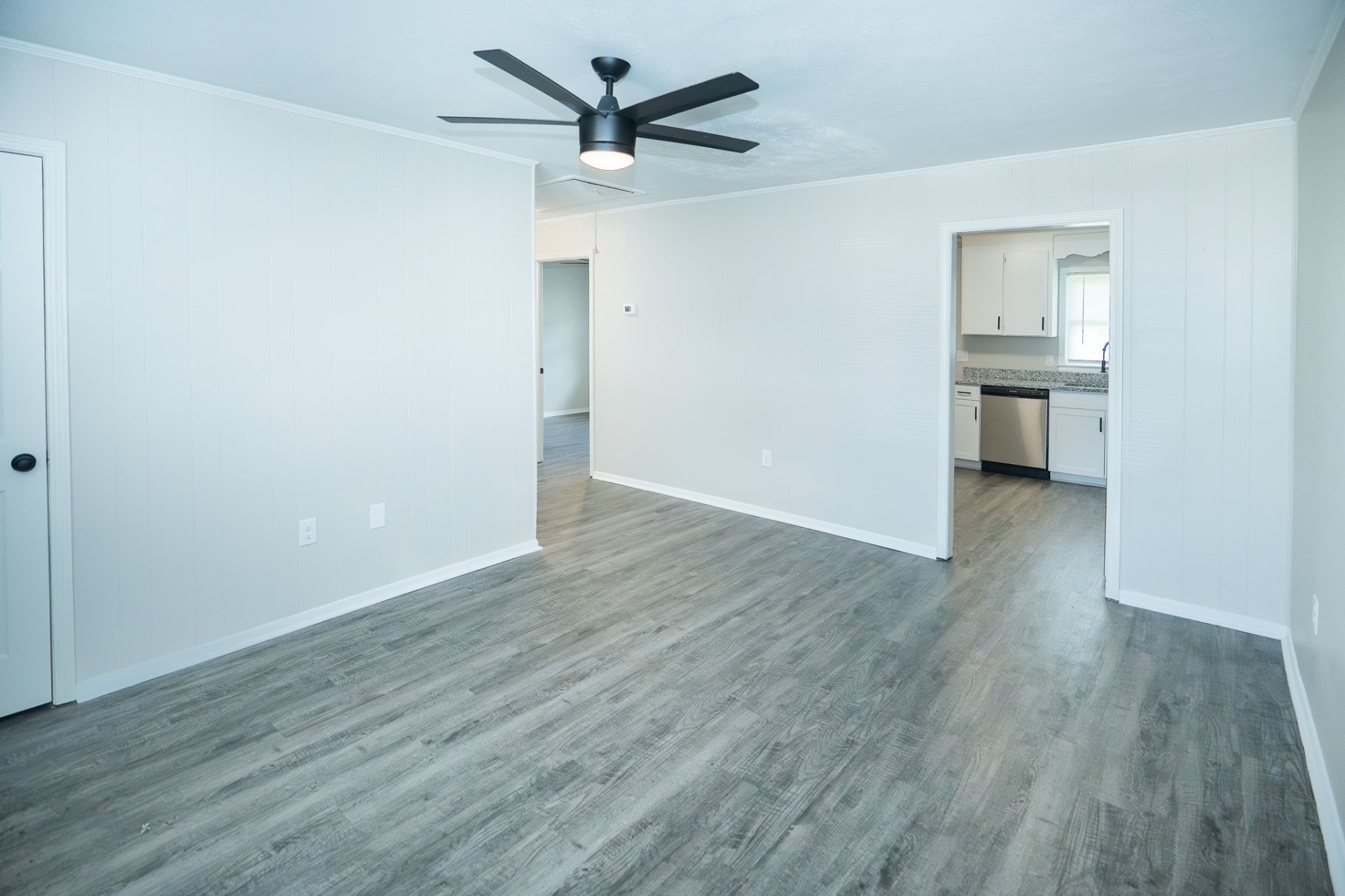 Renovated living room with ceiling fan and gray luxury vinyl plank flooring